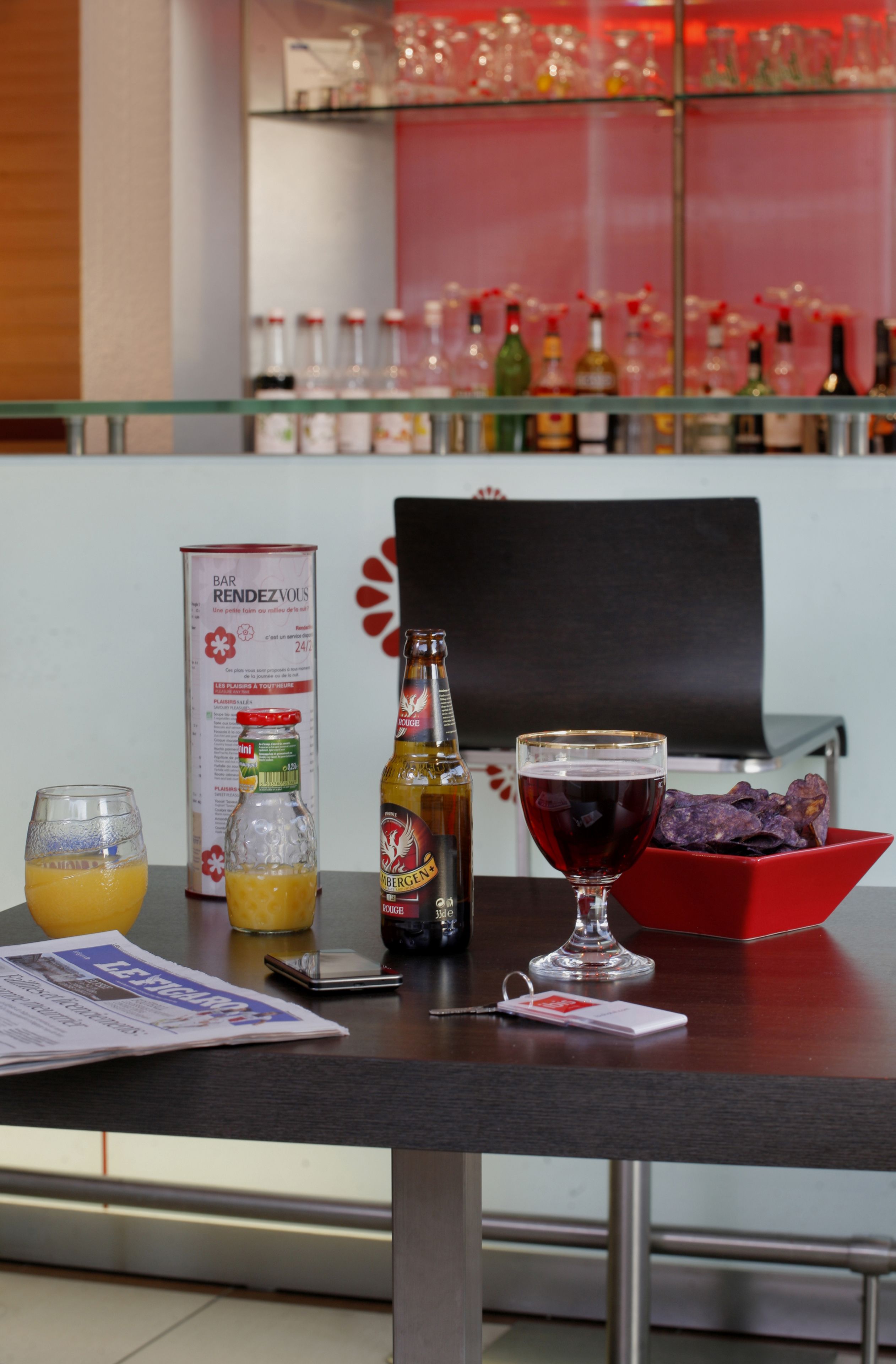 A bar area with a glass counter, bottles, glasses, and a menu board.