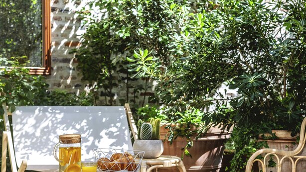 A wicker table with a glass pitcher, a glass of orange juice, and a basket of croissants. - ibis Styles Paris Nation Cours de Vincennes (Paris)