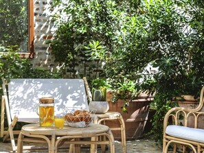 A wicker table with a glass pitcher, a glass of orange juice, and a basket of croissants. - ibis Styles Paris Nation Cours de Vincennes (Paris)