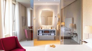 Una habitación de hotel moderna con separador de vidrio, cama, escritorio, tocador con repisas y un espejo grande.