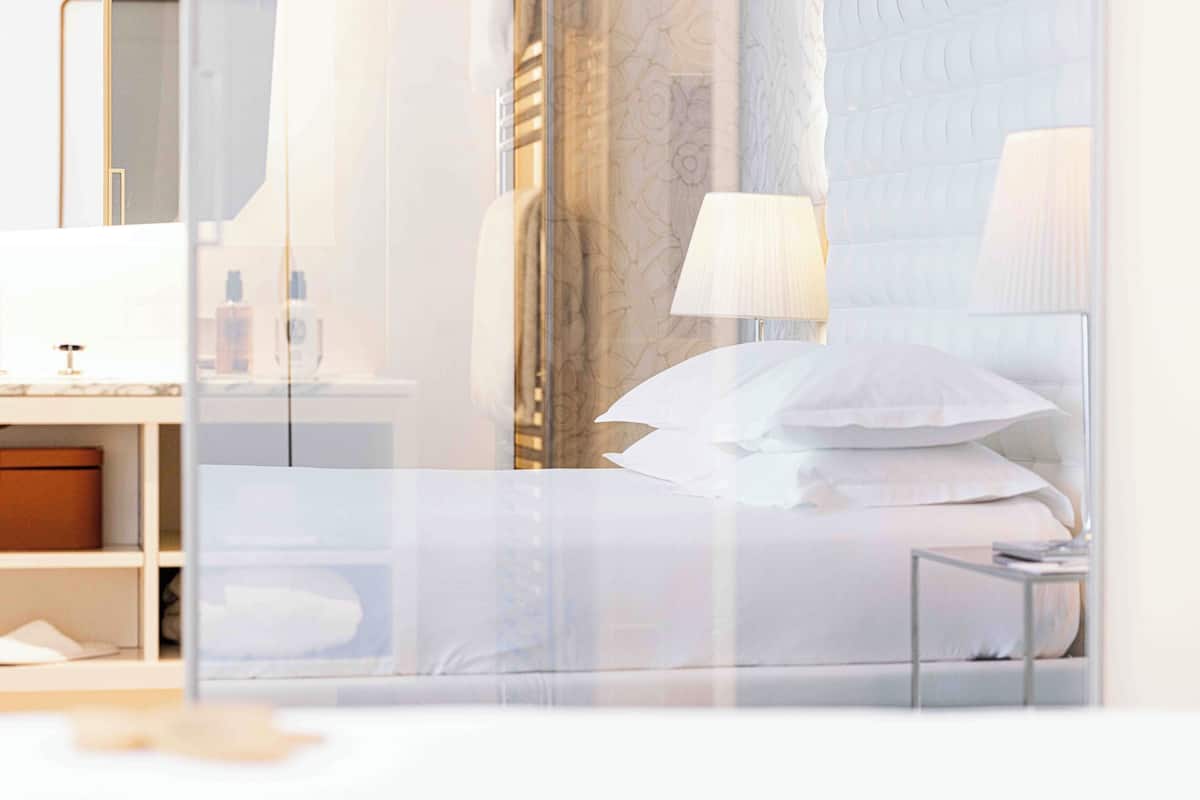 Een hotelkamer met een bed, nachtkastjes, een spiegel en een kledingkast.