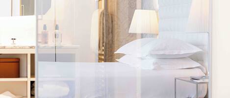A hotel room with a bed, bedside tables, a mirror, and a wardrobe.