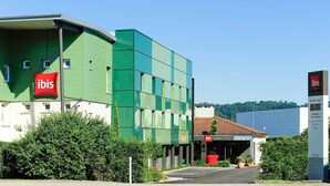 A modern hotel with a green facade and a red ibis logo. - ibis Lyon Est Beynost A42 (Beynost)