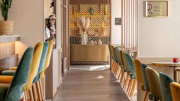 Un restaurant doté d’un plancher en bois, de rangées de chaises et d’une cloison décorative.