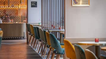A modern interior with a row of chairs, a reception desk, and a wall-mounted sign.