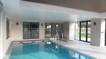 Una piscina techada, sillones reclinables de piscina