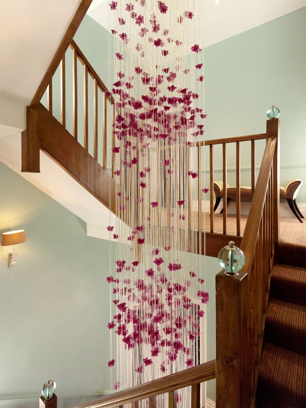 A staircase with wooden railings and a decorative string of purple flowers. - The Capital Hotel, Apartments & Townhouse - Small Luxury Hotels of The World (London)