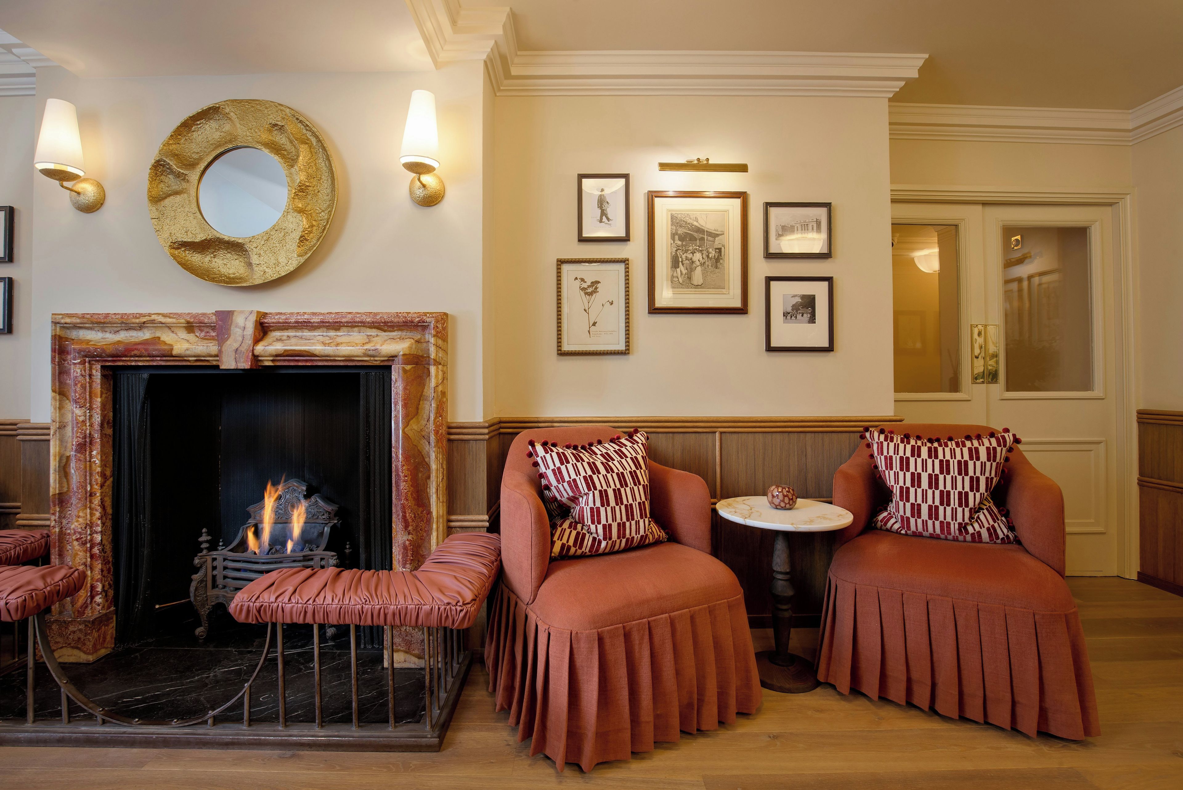 A room with a fireplace, seating area, and wall-mounted artwork.