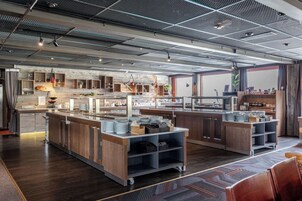 A modern kitchen with wooden cabinets, stainless steel appliances, and a central island with a sink and counter space.