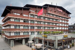 A multi-story hotel with balconies, a restaurant, and a flag.