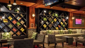 A modern lounge area with a sofa, armchairs, and a TV screen.