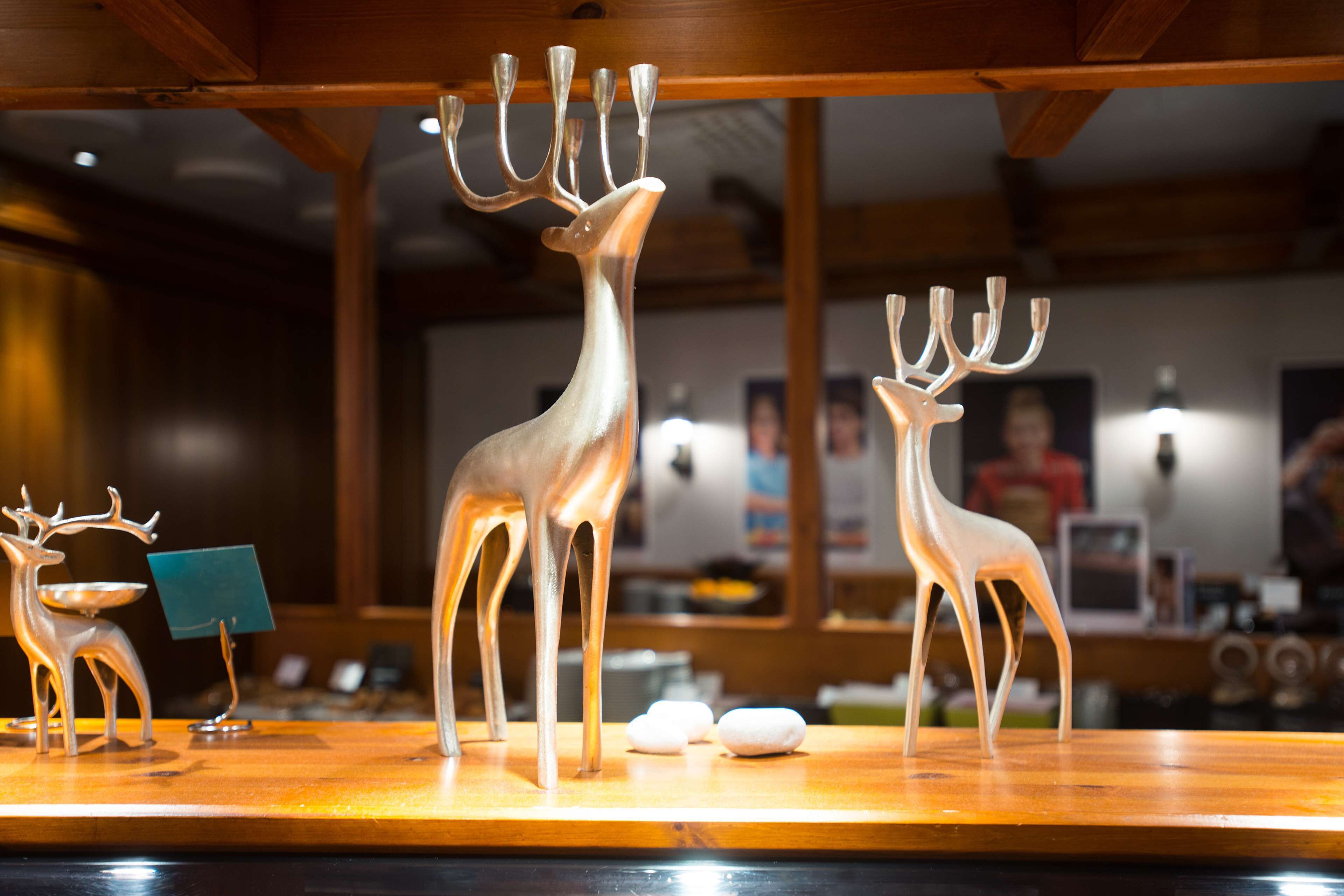 Une table en bois ornée de trois figurines de cerfs et d’une petite carte bleue.