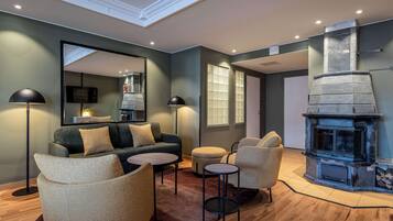 A modern living room with a fireplace, a sofa, armchairs, and a coffee table.