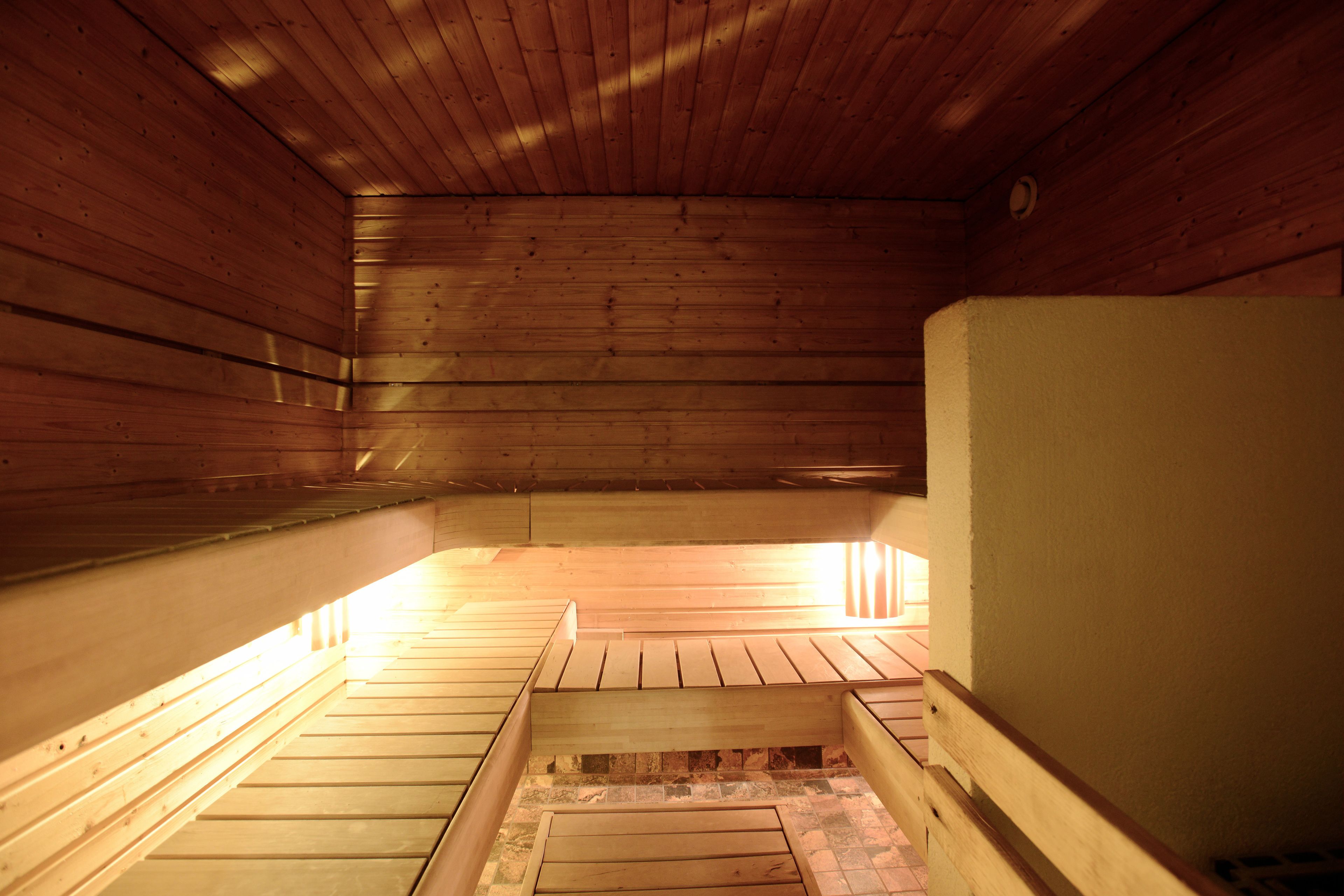 A sauna with wooden benches and a tiled floor.