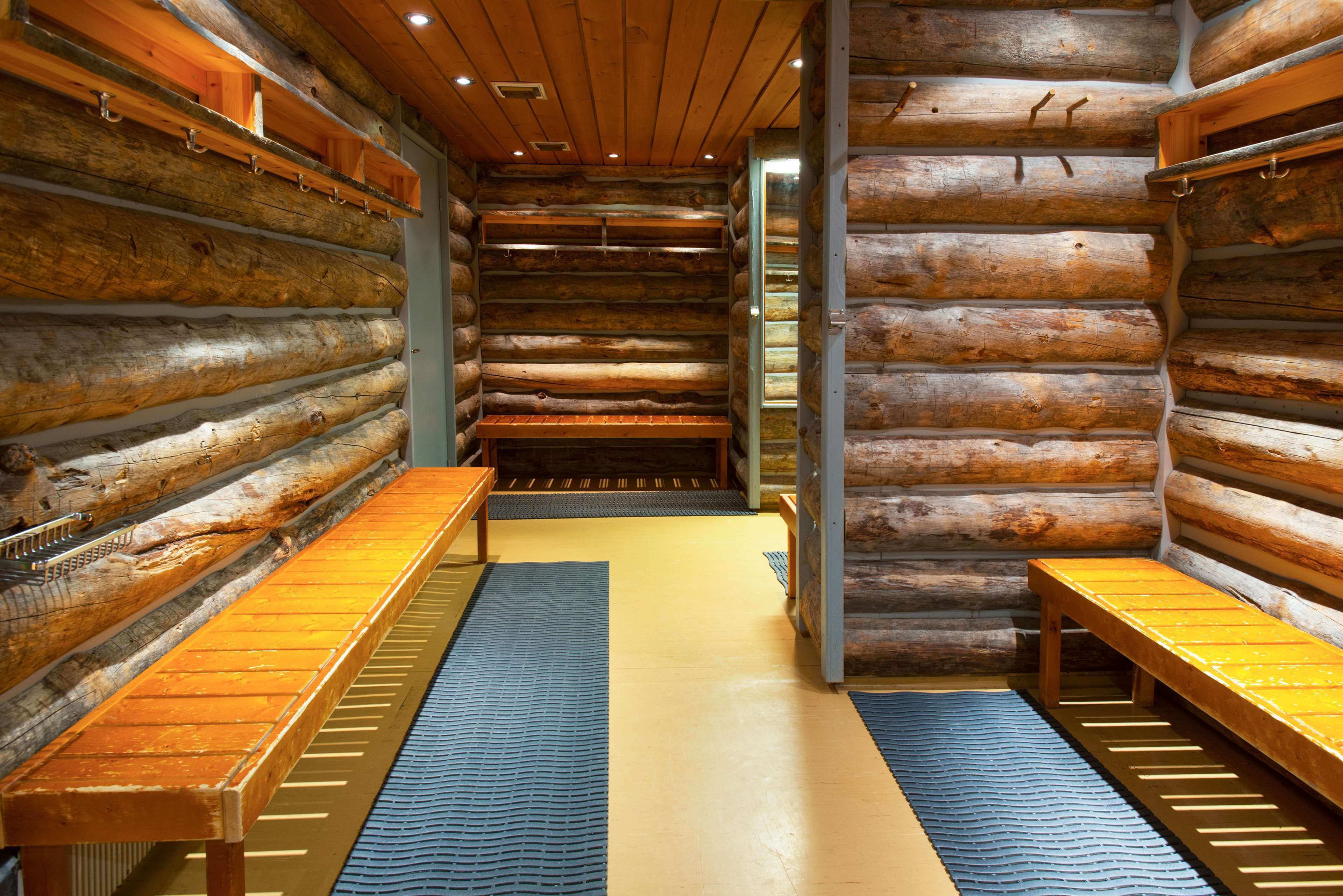 A log cabin interior with benches along the walls and a central aisle.