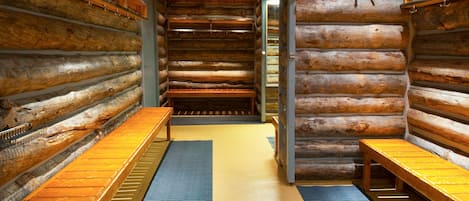 A log cabin interior with benches along the walls and a central aisle.