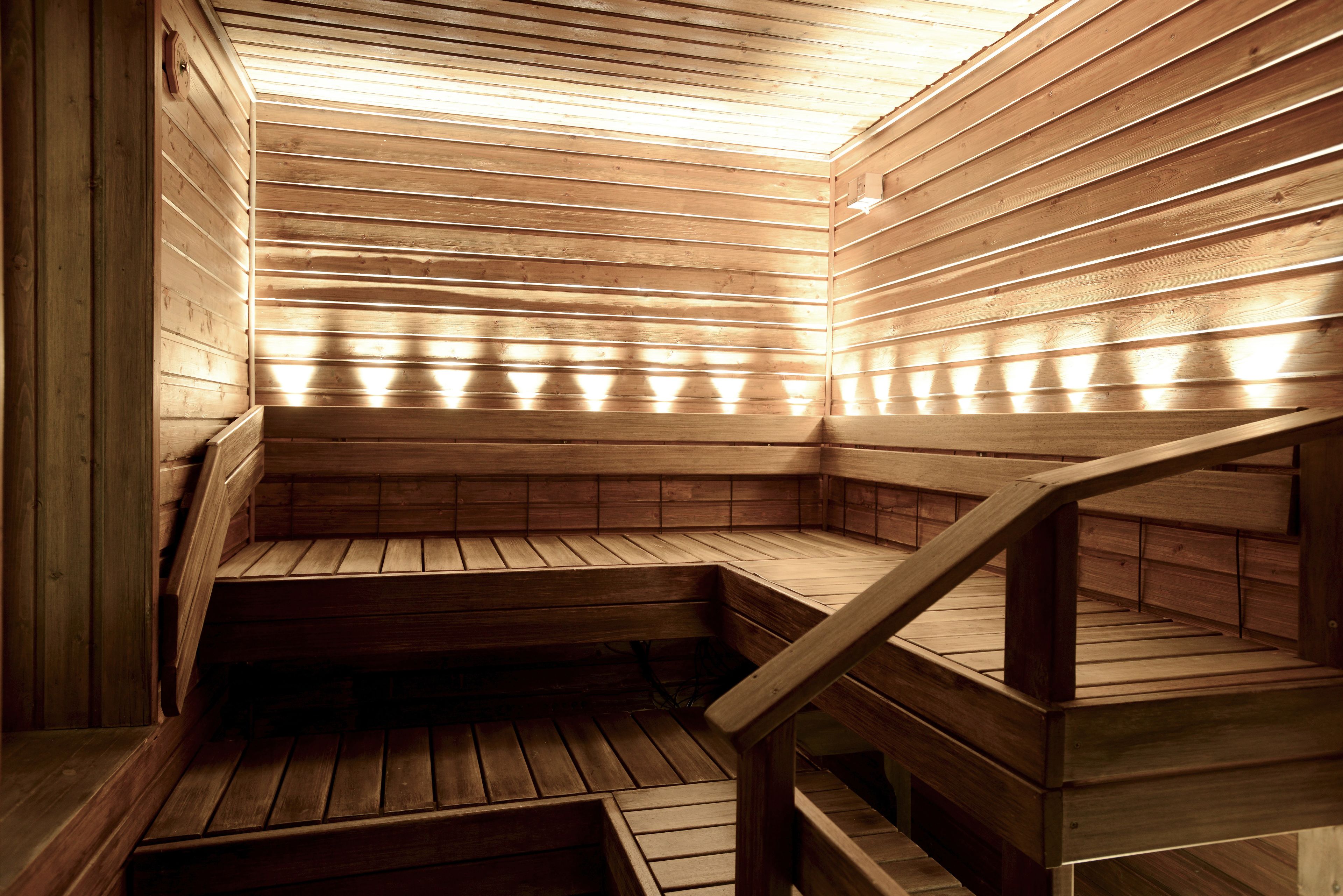 A sauna with wooden benches and a sloped ceiling.