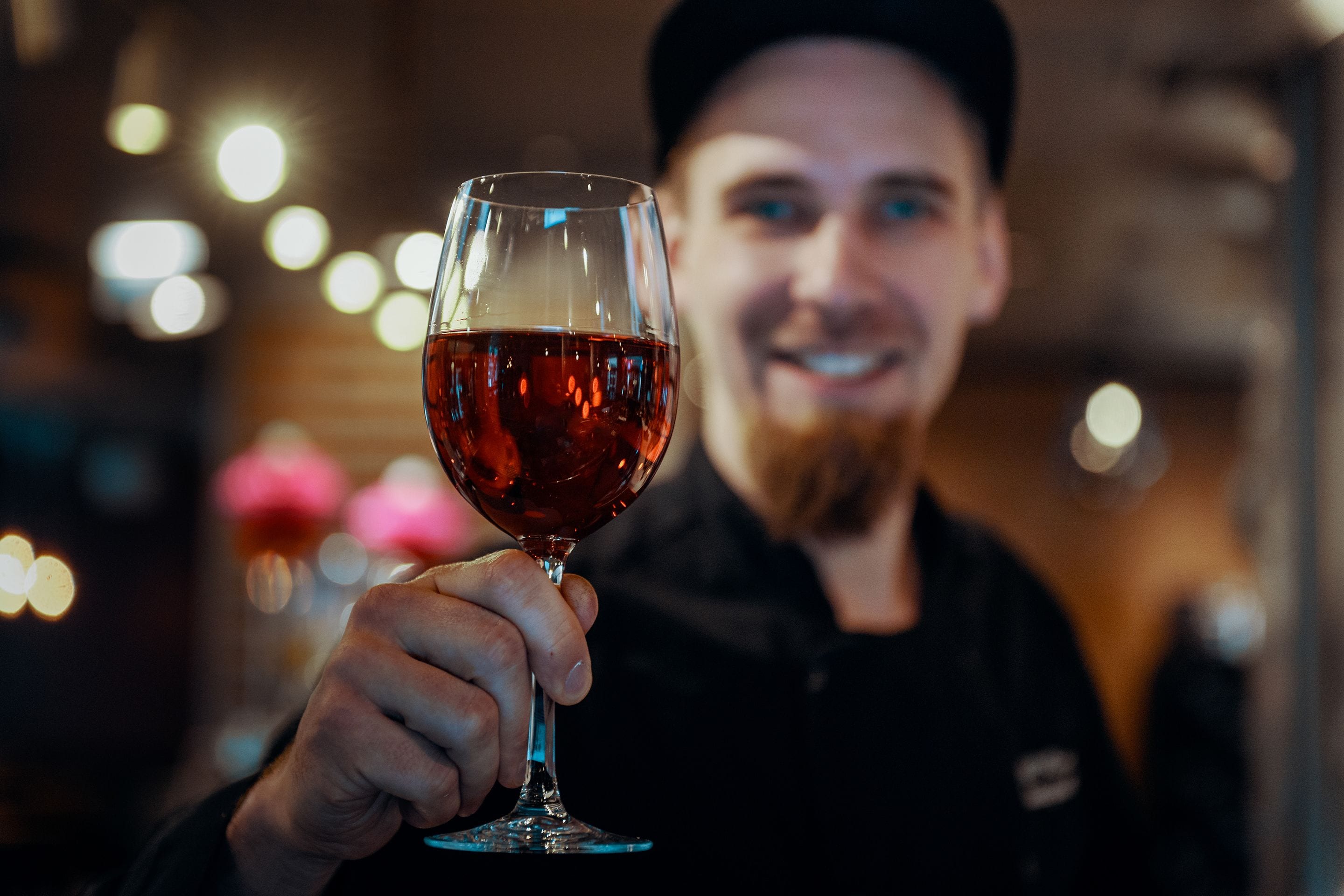 A person holding a glass of red wine.