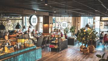 Un interno di un caffè con bancone barista, zona salotto e esposizione di caffè.