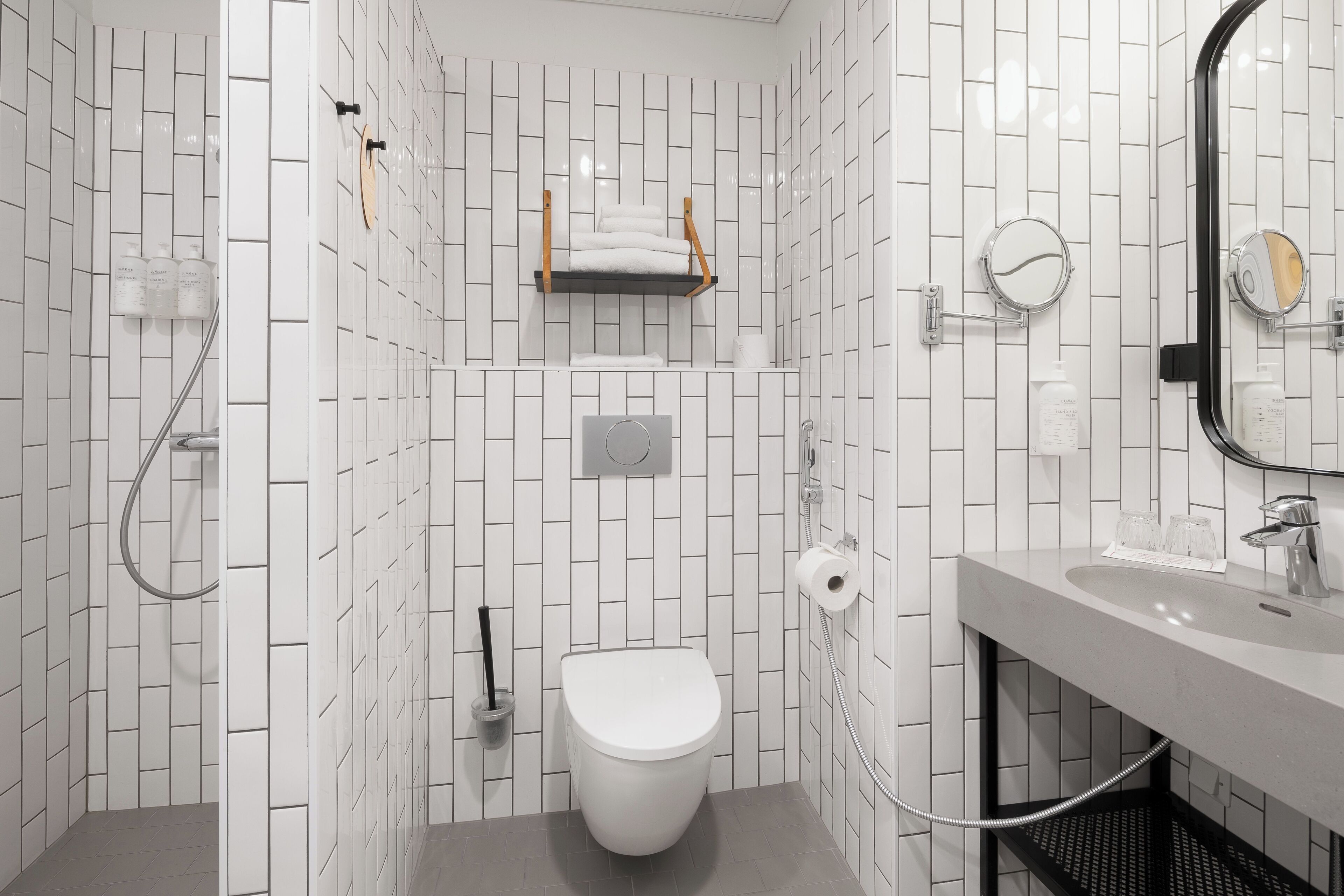 Une salle de bain moderne équipée de toilettes, d’une douche et d’un lavabo.