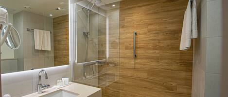 A modern bathroom with a glass-enclosed shower, a large mirror, and a wooden wall.