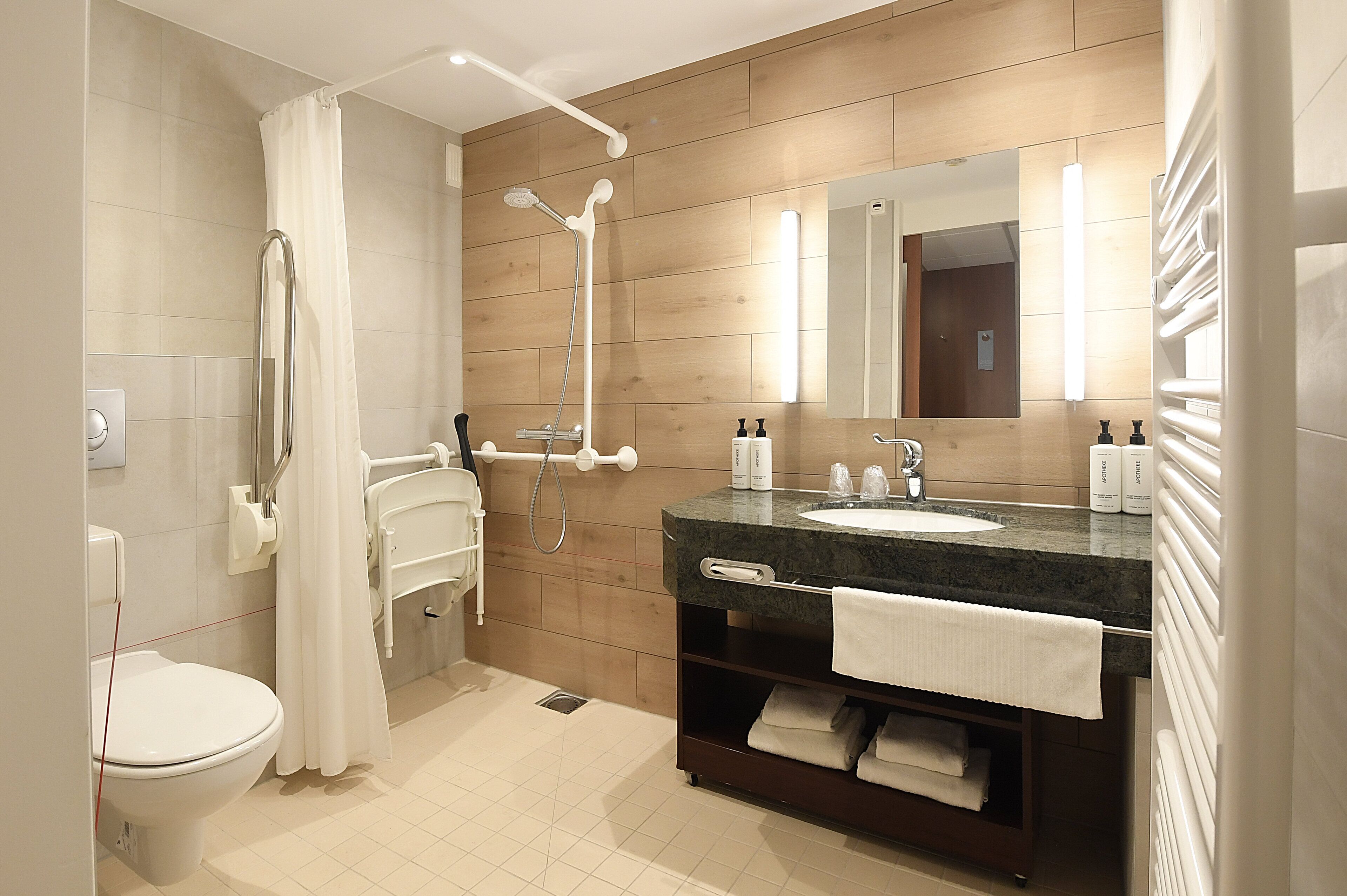 Un baño moderno con ducha, inodoro y lavamanos.