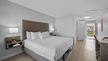 Een moderne hotelkamer met een groot bed, nachtkastjes, een bureau en uitzicht.