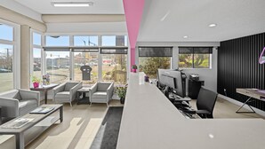A modern office space with a reception desk, multiple computer monitors, and seating areas. - The Vista Inn (Kamloops)