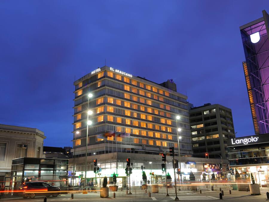 A multi-story hotel with illuminated windows and a sign reading "HOTEL EL ARAUCANO".