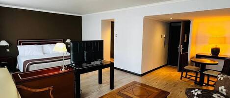 Una sala de estar moderna con sofá, sillón, mesa de centro y televisor.