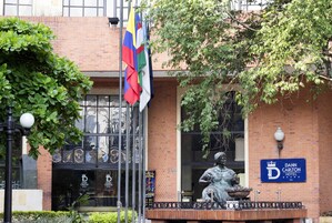 A building with a sign for Dann Carlton Hotel, a statue, and a flag.