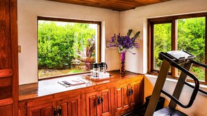 A room with wooden cabinets, a treadmill, and a window with a view of greenery. - Gateway Coonoor (Coonoor)