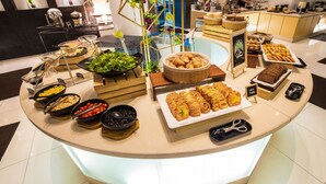 A buffet setup with various food items and a sign indicating 'CANDY PASTRY'.
