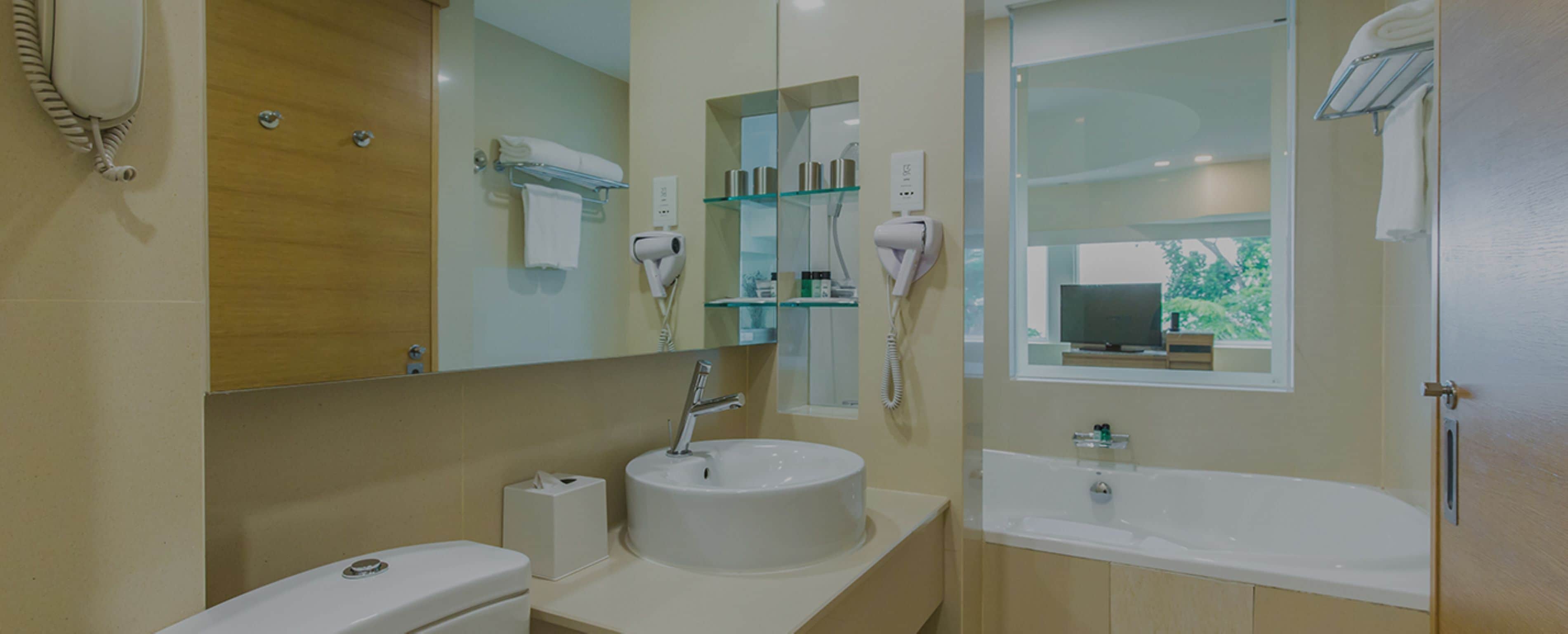 Un baño moderno con lavamanos, inodoro y cabina de ducha con paredes de vidrio.