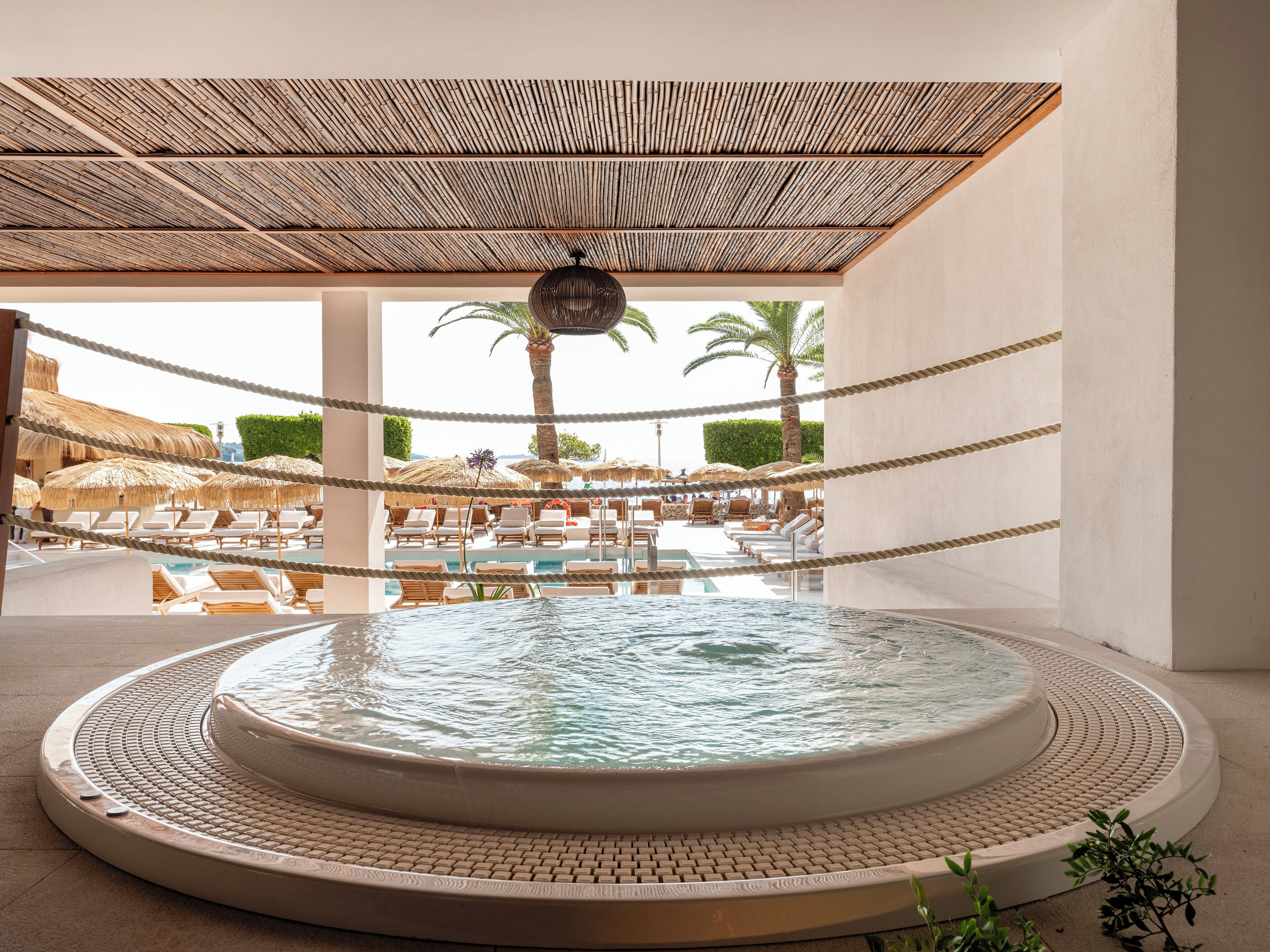 Ett poolområde med solstolar och en bubbelpool.