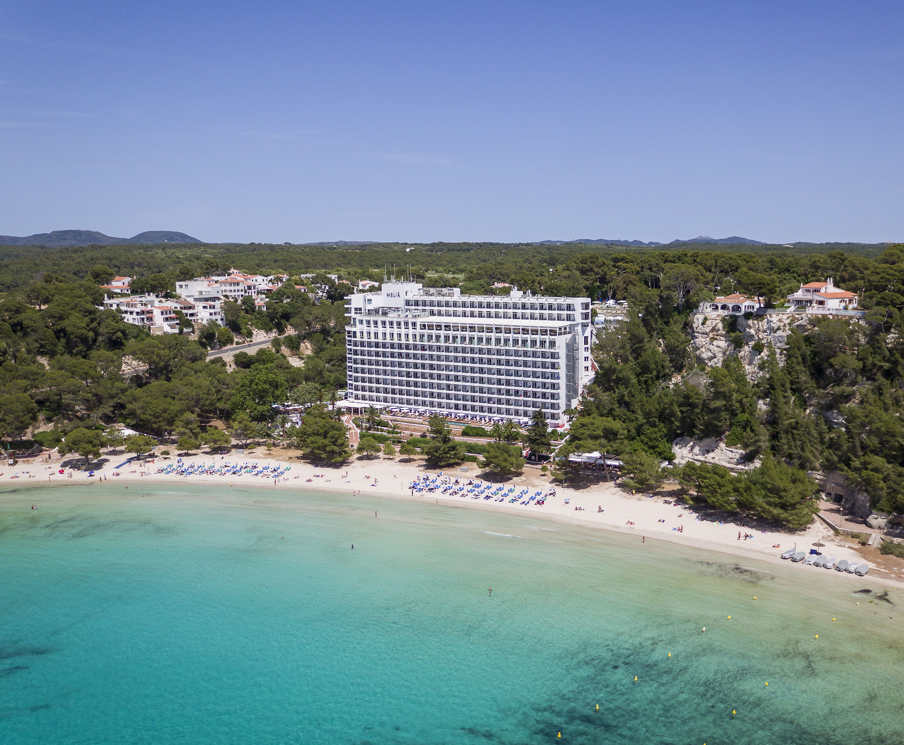 Un hotel grande con varios pisos y una playa al frente.