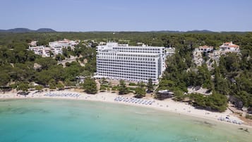 Un hotel grande con varios pisos y una playa al frente.