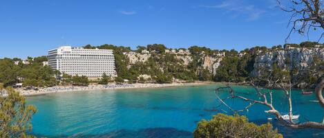 A coastal hotel with a view of the sea and a cliff.