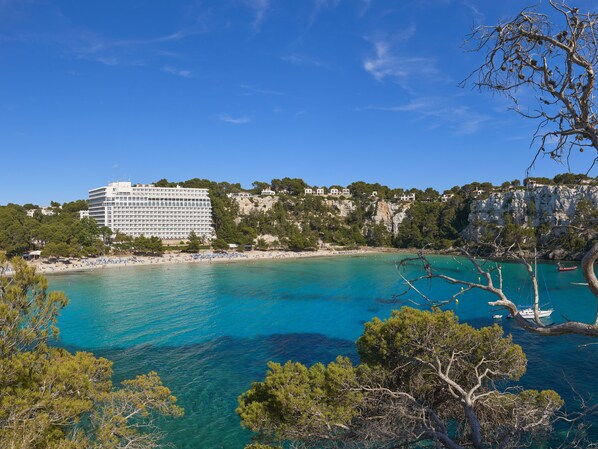 Un hôtel situé sur la côte, offrant une vue sur la mer et une falaise.