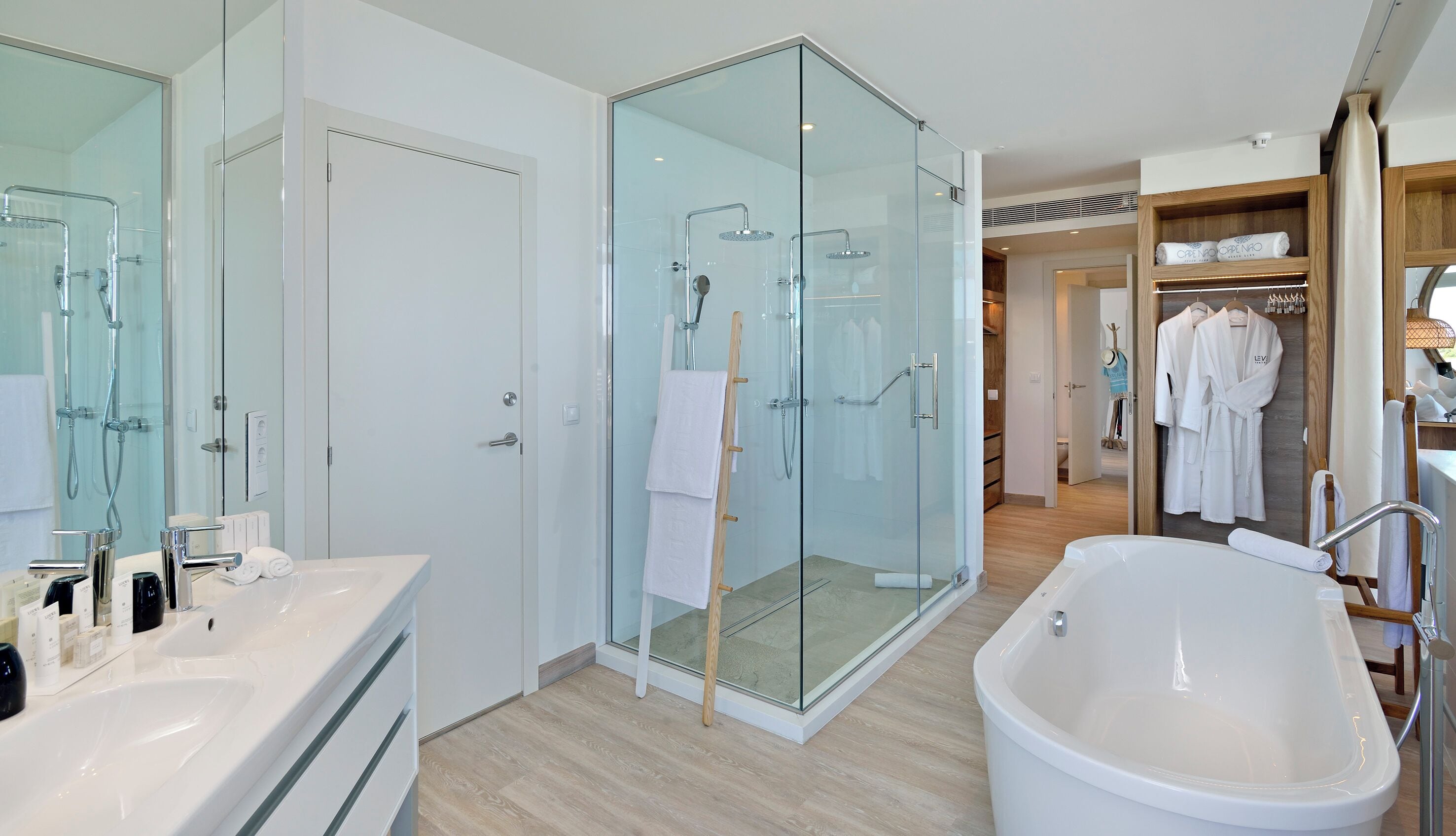 Un baño moderno con ducha de vidrio, una bañera independiente y un tocador con espejo.
