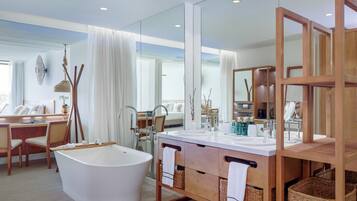 Un baño moderno con una bañera independiente, tocador de madera y un espejo grande.