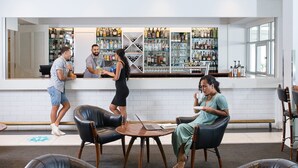 A bar area with a counter, seating, and a variety of bottles on shelves. - Holiday Inn Suva by IHG (Suva)