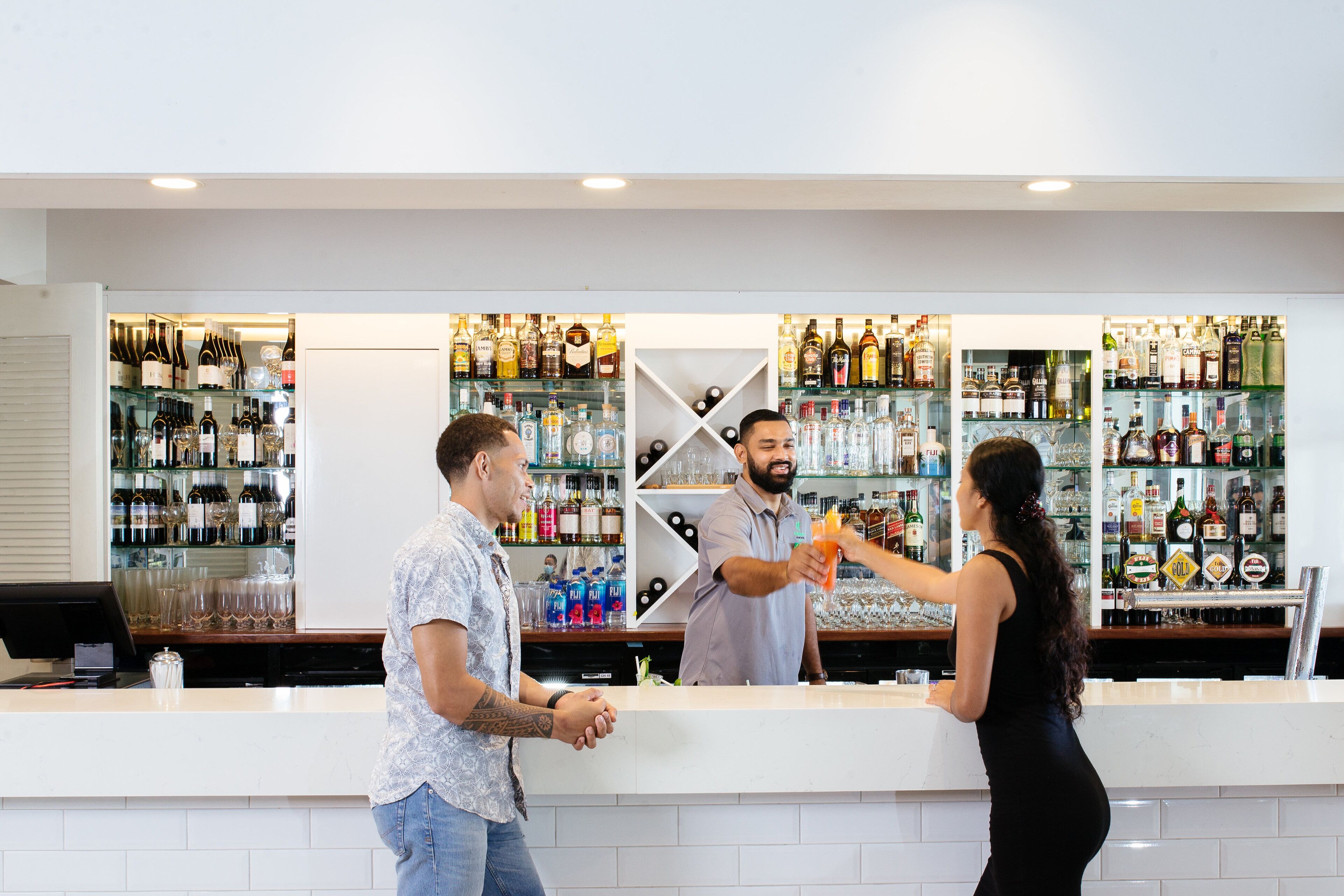 Un espace bar avec des étagères remplies de différentes bouteilles d’alcool et de verres.
