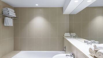 Une salle de bain moderne avec une baignoire, un lavabo et un porte-serviettes.