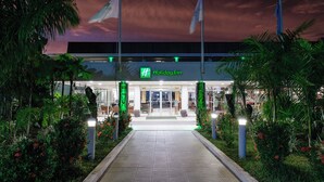 A Holiday Inn entrance with a well-lit pathway, surrounded by greenery and palm trees. - Holiday Inn Suva by IHG (Suva)
