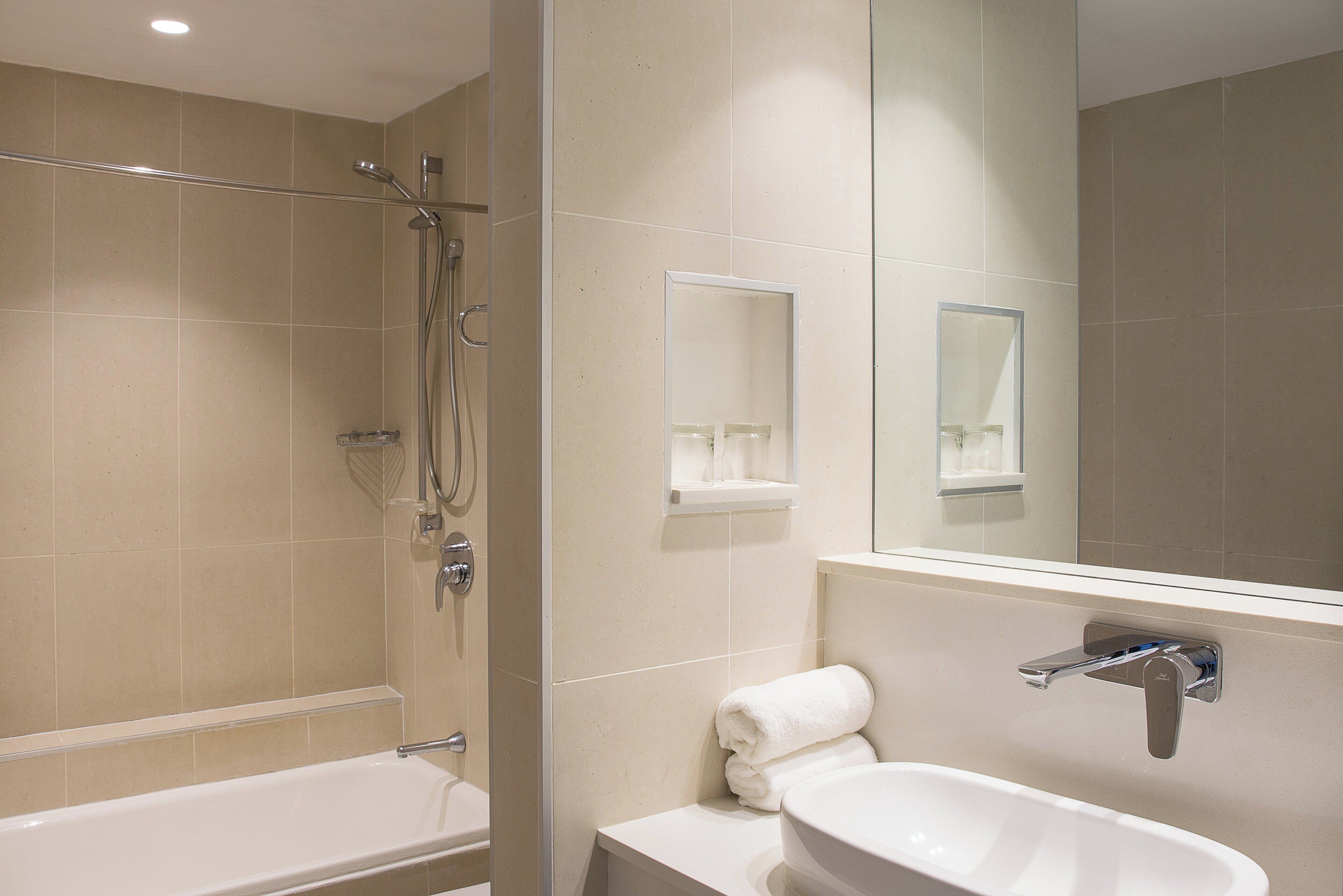 Un baño moderno con bañera, lavamanos y ducha.