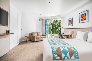 A hotel room with a bed, a sofa, a desk, and a view of the outdoors. - Holiday Inn Suva by IHG (Suva)