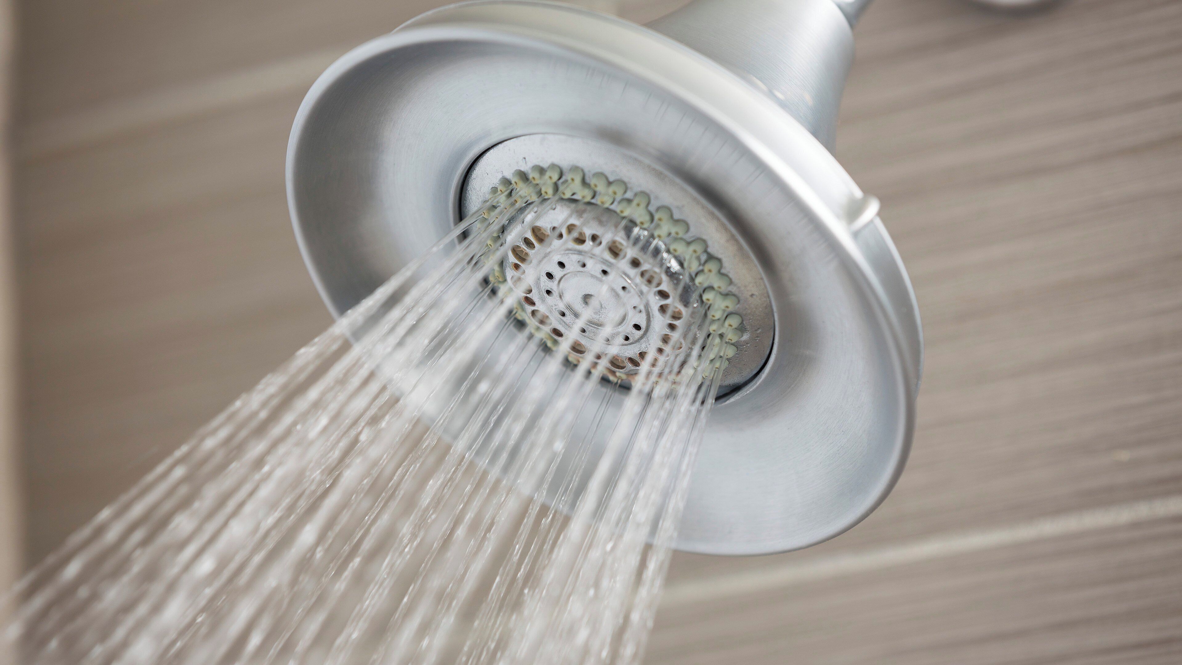 A showerhead with water flowing from it.
