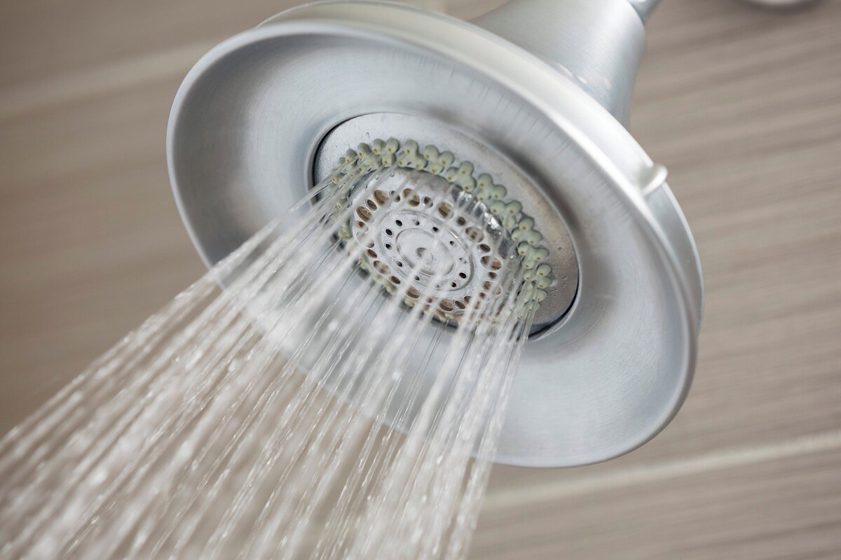 A showerhead with water flowing from it.