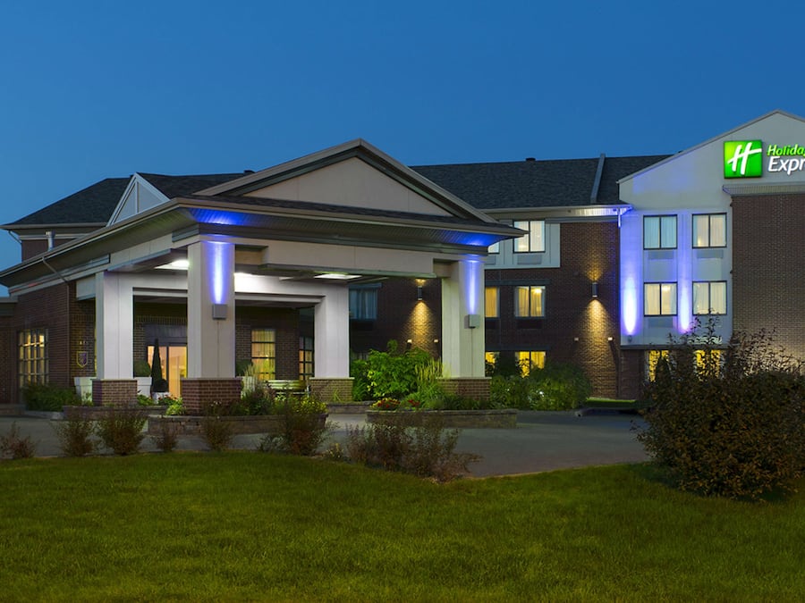 A Holiday Inn Express hotel with a well-lit entrance, a covered outdoor area, and a brick facade.